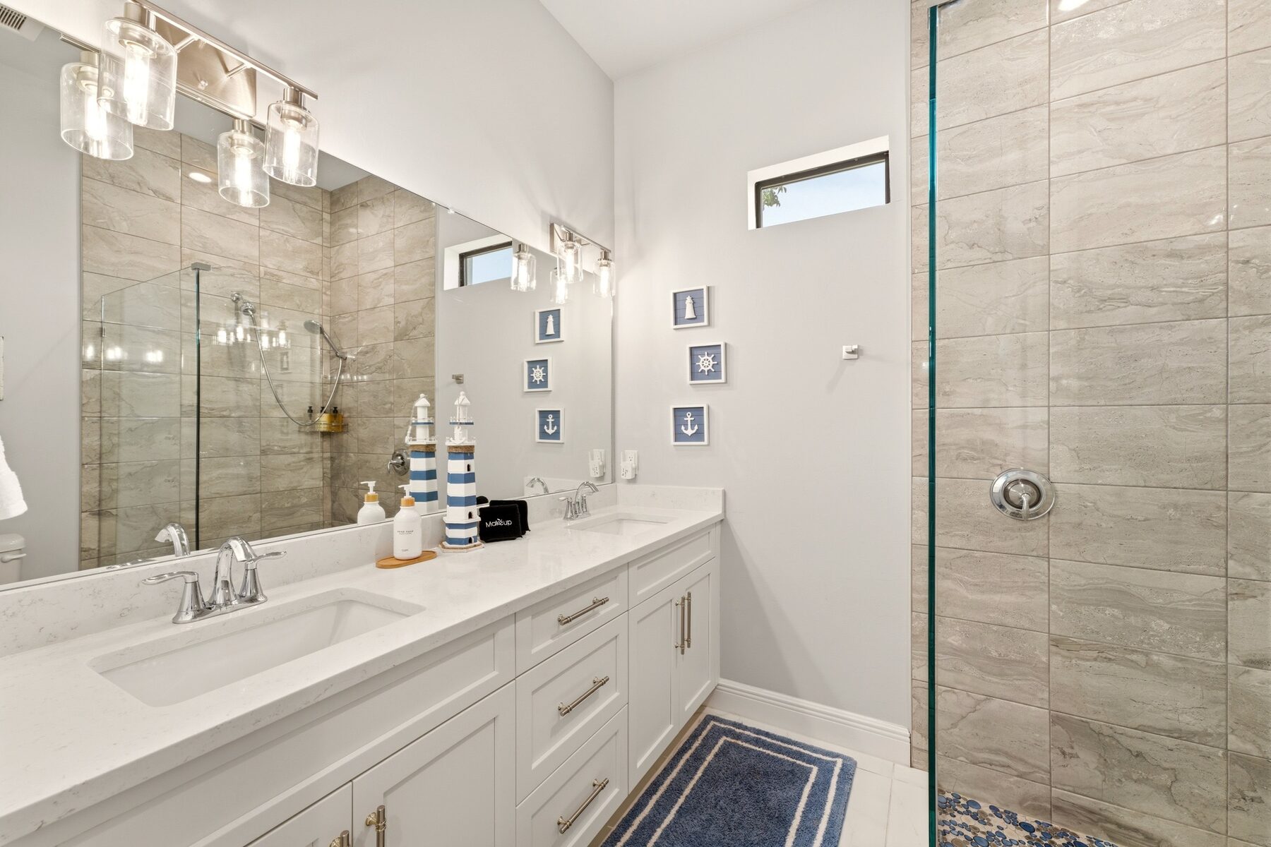 Bright double-vanity bathroom with a walk-in tiled shower